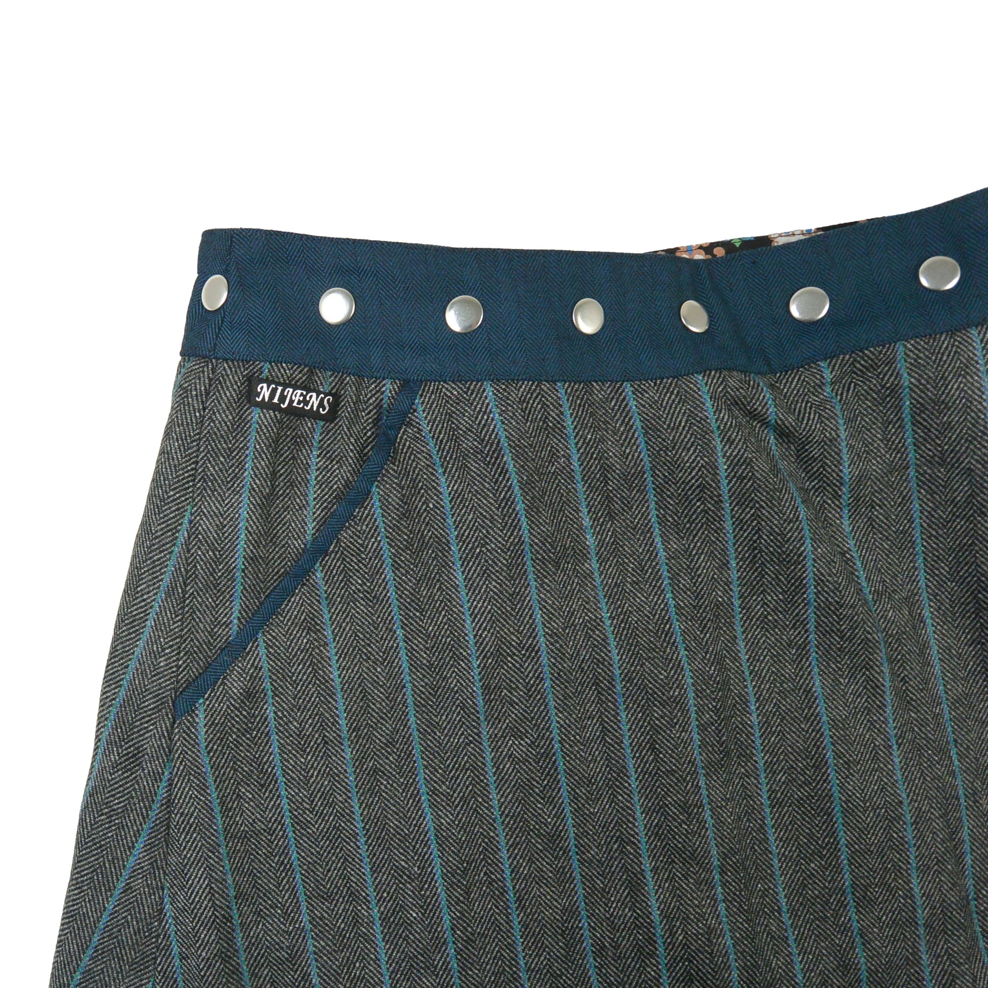 Detailansicht Tasche und Bund des türkis-grauen Tweed-Wickelrocks mit Druckknöpfen von Nijens
