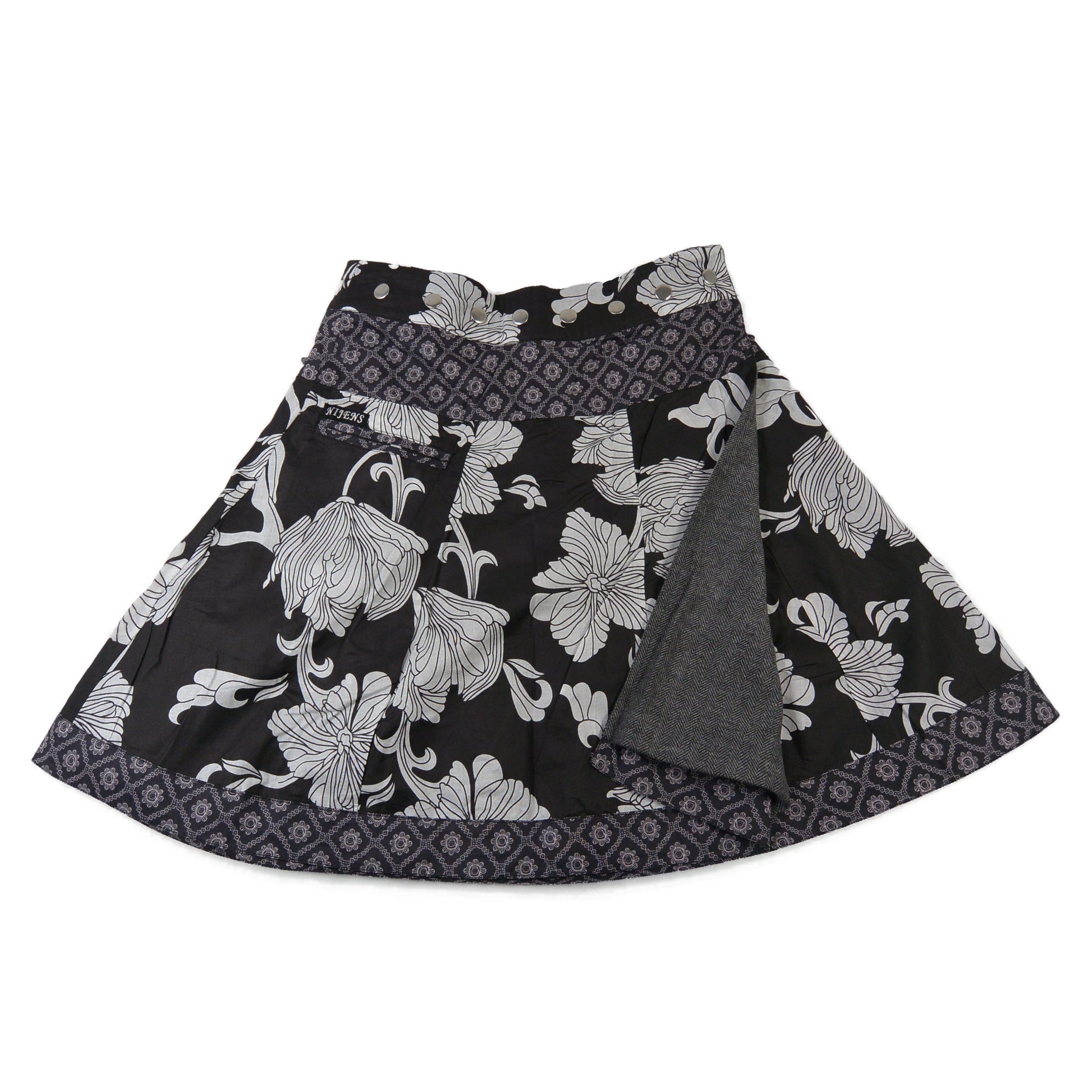 Reversibler Nijens Wenderock aus Tweed in Schwarz mit floralem Muster, geöffnet gezeigt mit sichtbarer Innenseite in Grau. Winterrock mit 2 Looks.