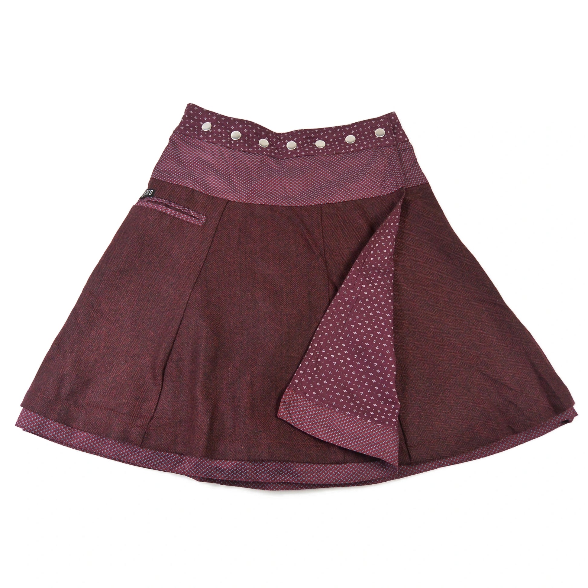 Nijens Winter-Wenderock in Bordeaux mit dunkelroter Tweed-Seite und gemustertem Bund. Reversibler Wickelrock mit sichtbarer Innenseite im feinen Punktmuster.