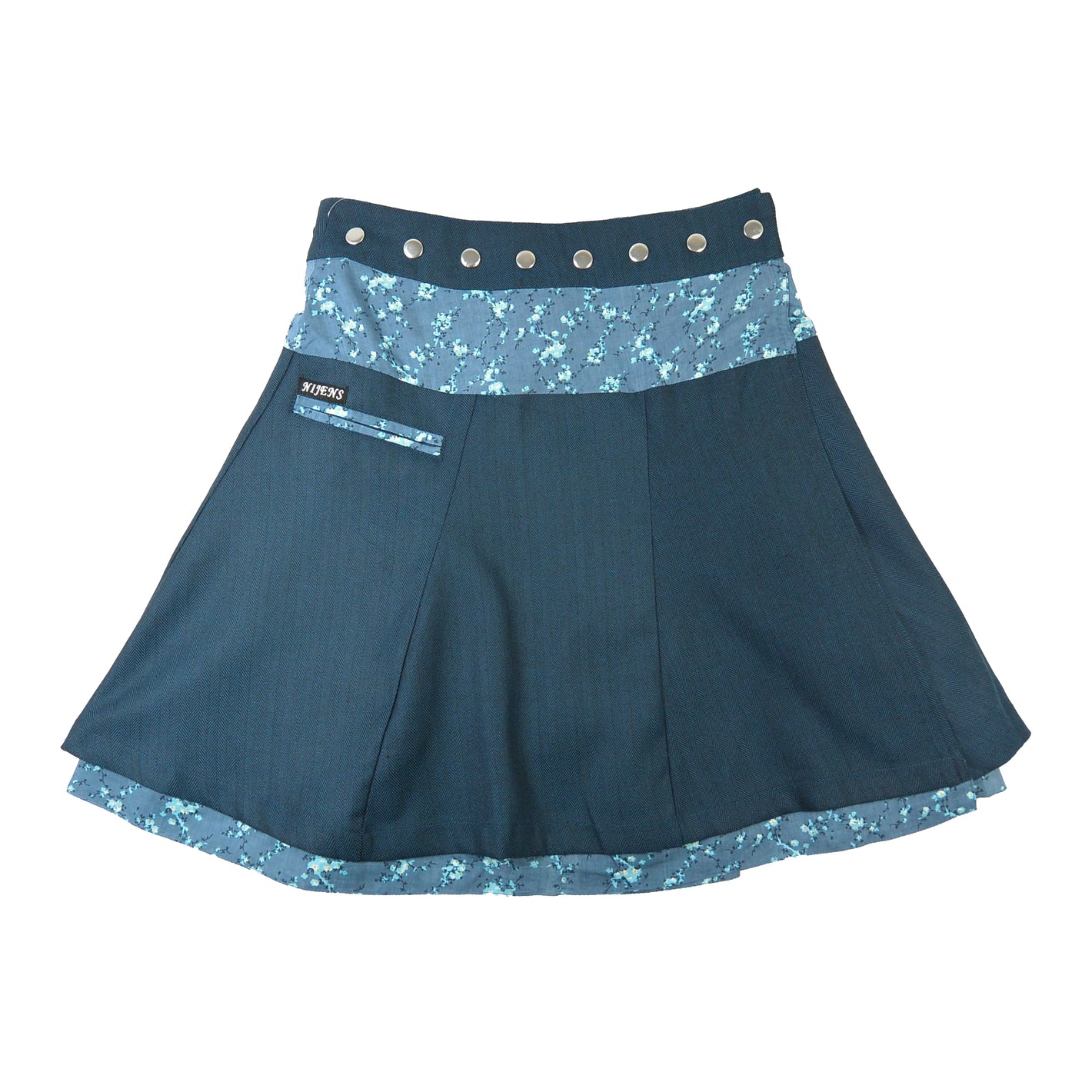 Nijens reversibler Winter-Wenderock in Petrol mit türkis-blauem Blumenbund. Warmer Tweed-Wickelrock mit zwei Looks für den Winter.