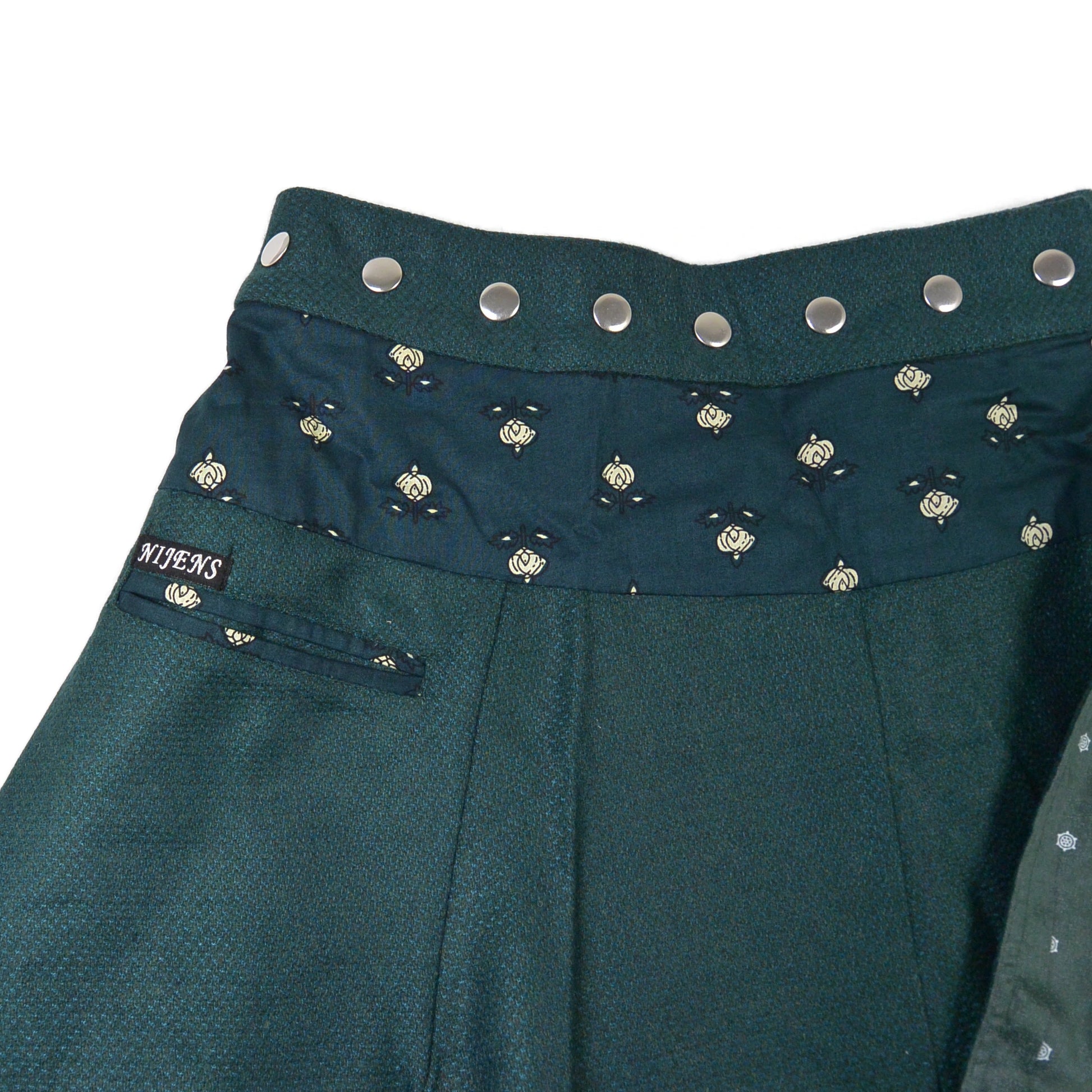 Detailaufnahme des Nijens Wenderocks in Dunkelgrün mit feiner Struktur und aufgeklappter Innenseite. Reversibler Winterrock.