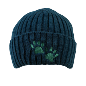 Warme Beanie aus 100 % Schurwolle in Dunkelpetrol mit zwei grünen gestickten Hundepfoten auf dem Umschlag.