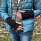 Model präsentiert Pulswärmer Zopfstrickmuster Schwarz mit Schlitz für Daumen.