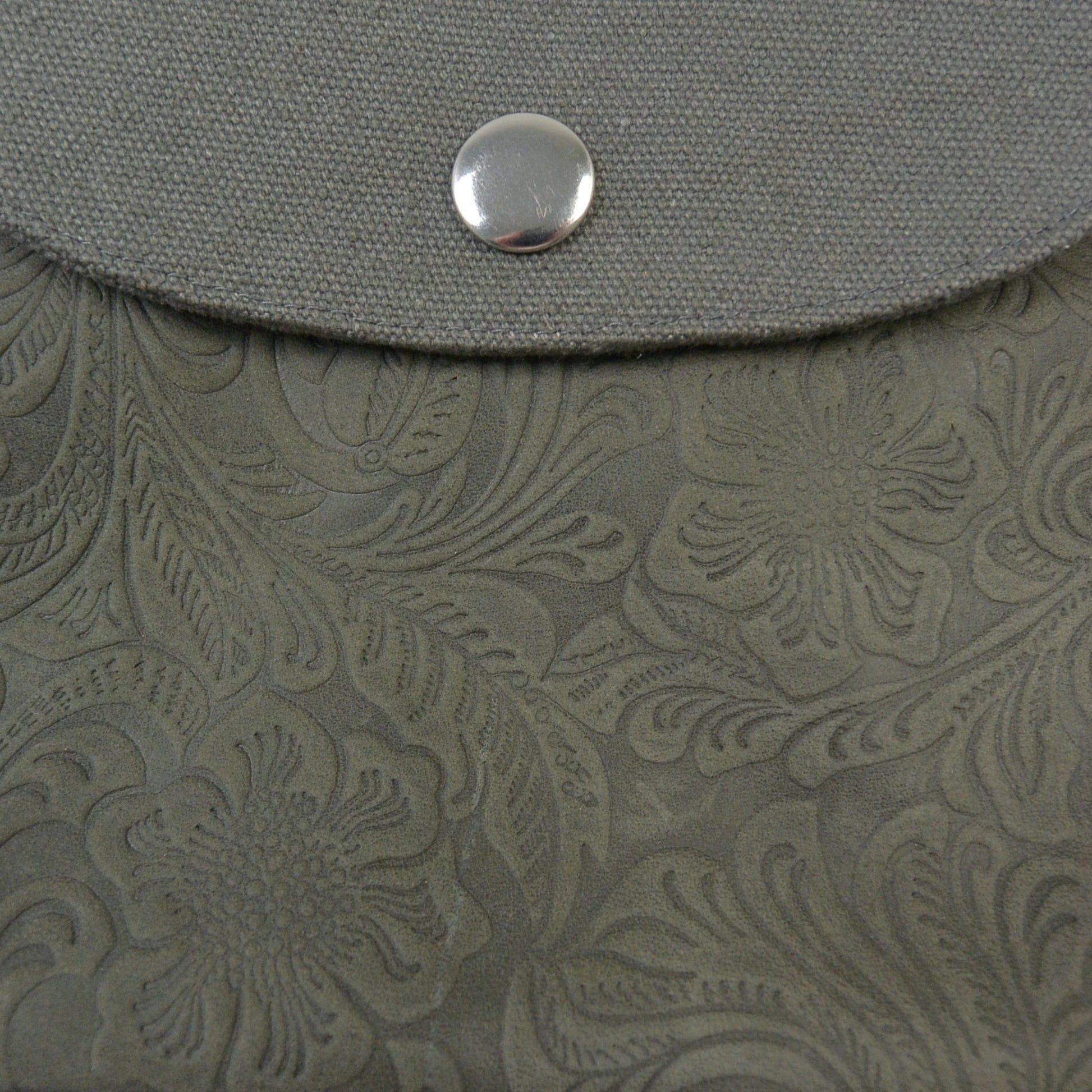 Nahaufnahme des floralen Musters auf dem Leder der Gassi-Tasche – dezente Ornamente in grau-oliv..