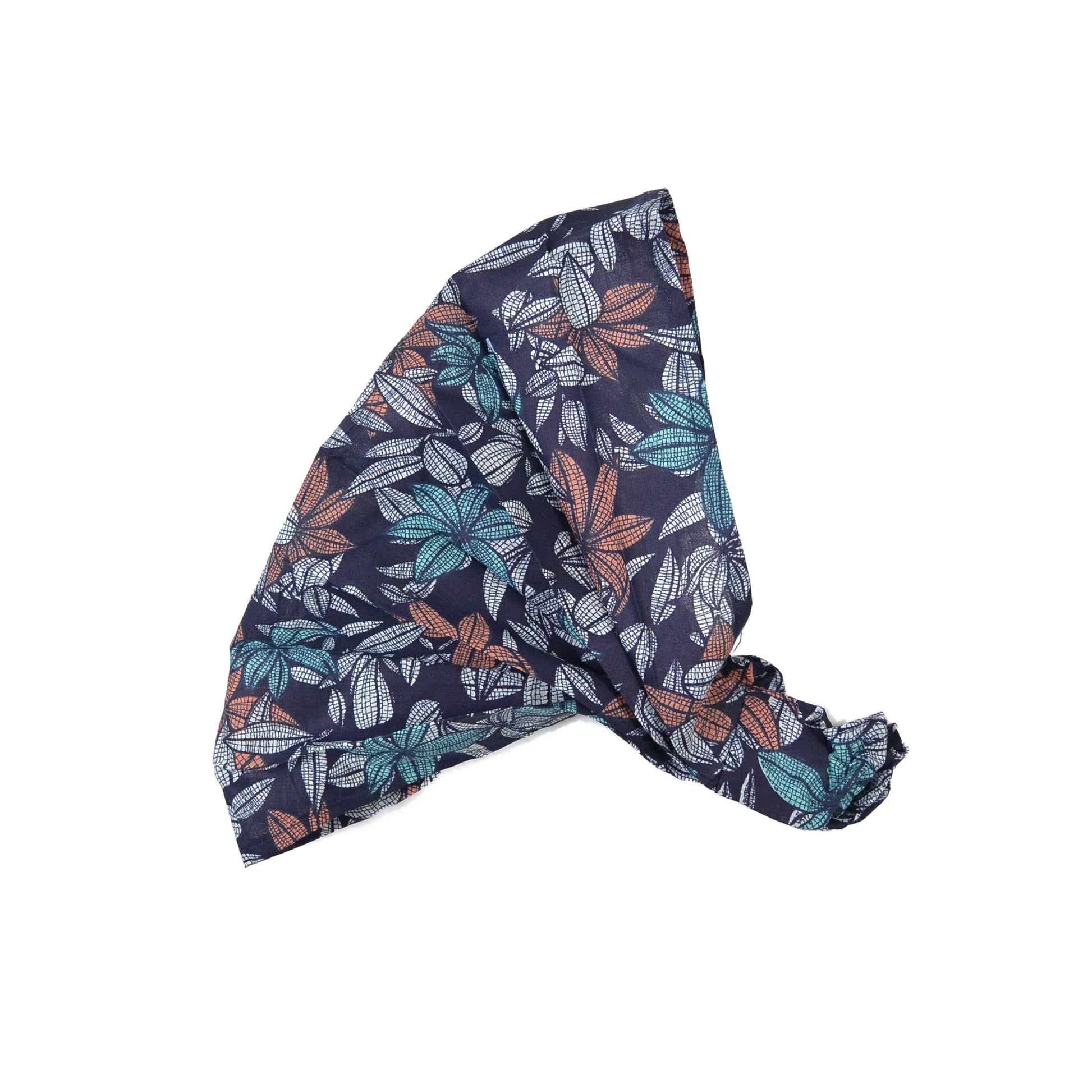 Nijens Stoff-Haarband in Dunkelblau mit Blattmuster in Türkis, Rostorange und Weiß, seitlich liegend vor weißem Hintergrund