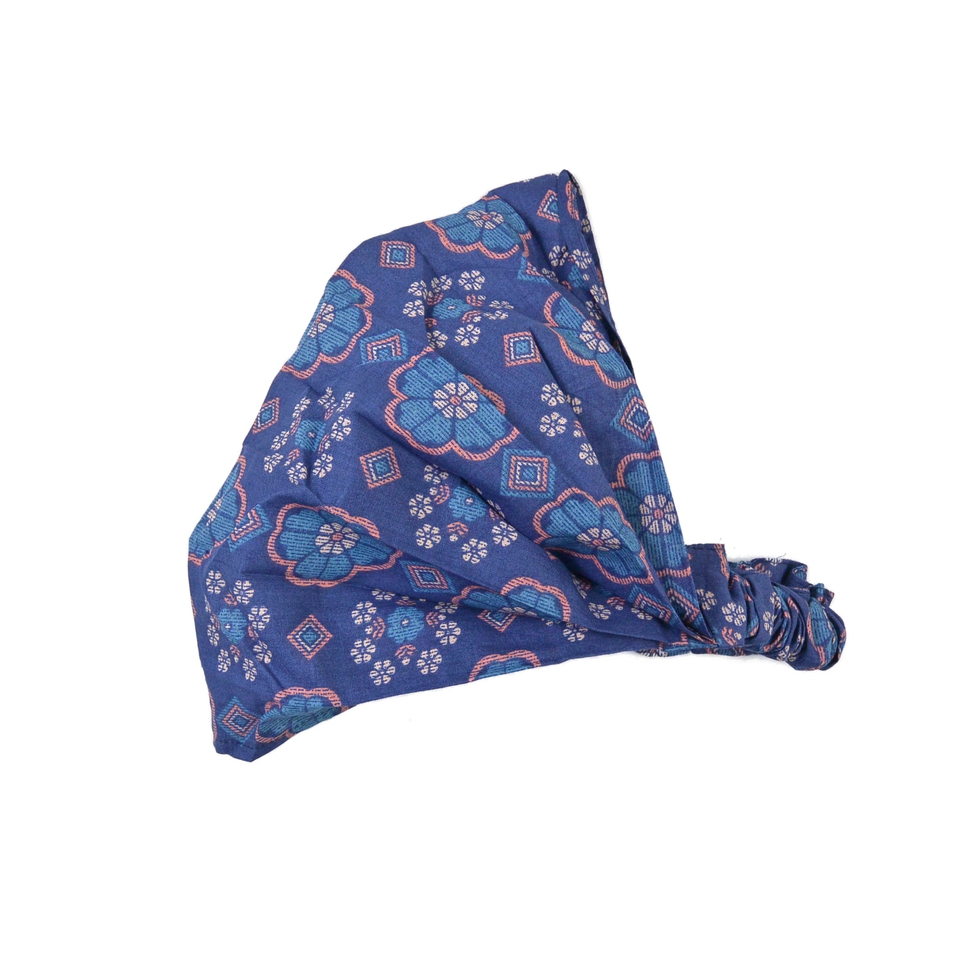 Nijens Stoff-Haarband in Blau mit rosa Blumenmuster, seitlich liegend vor weißem Hintergrund