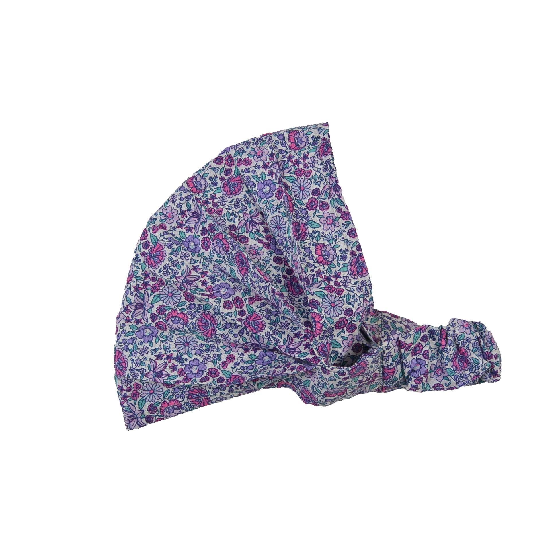 Nijens Stoff-Haarband in Lavendel mit kleinem Blumenmuster in Türkis, Rostorange und Weiß, seitlich liegend vor weißem Hintergrund