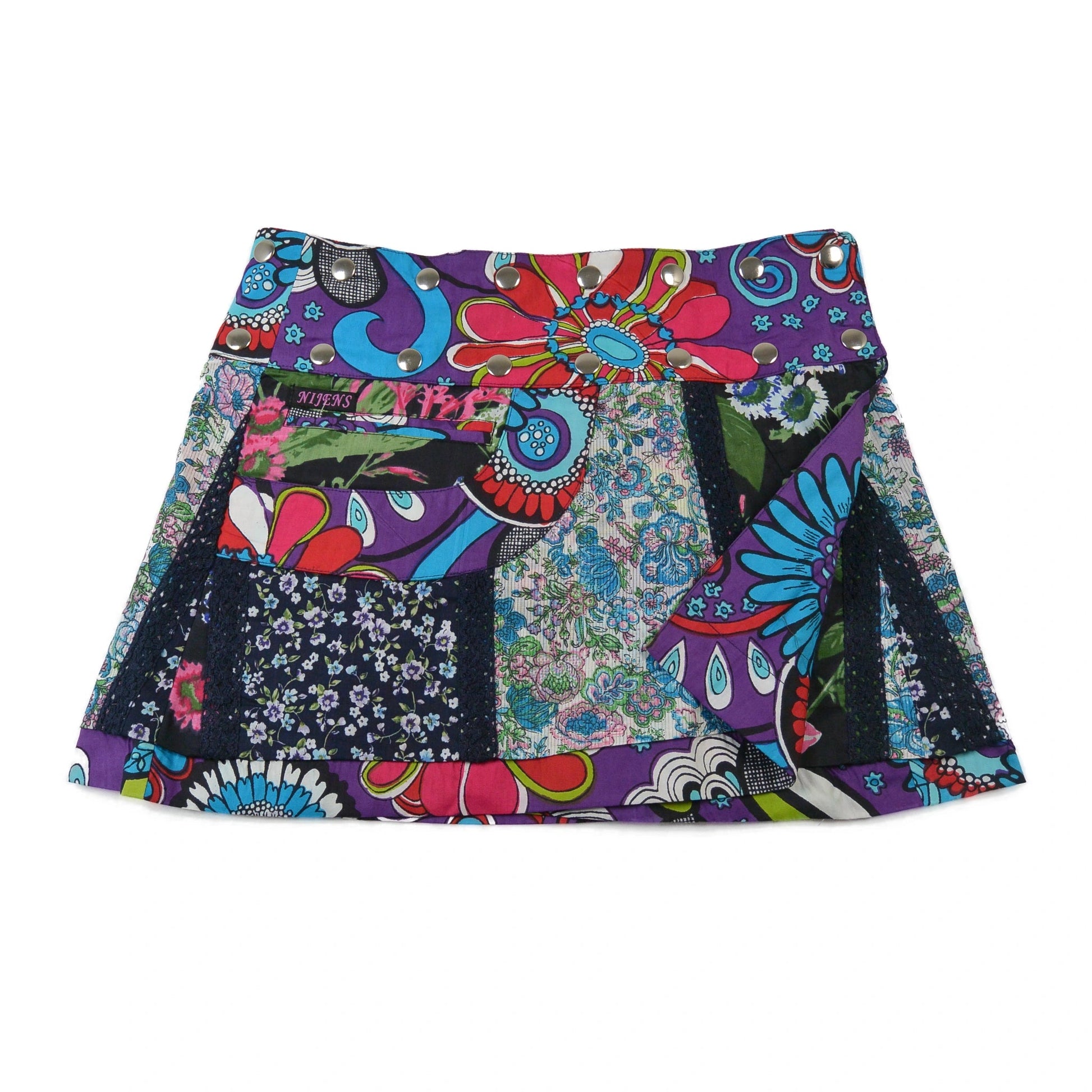 Kurzer Wenderock von Nijens im floralen Patchwork-Look mit leuchtenden Farben – Lila, Türkis, Rot und Blau – kombiniert mit kleiner Tasche und verspieltem Bund.