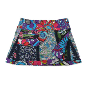 Kurzer Wenderock von Nijens im floralen Patchwork-Look mit leuchtenden Farben – Lila, Türkis, Rot und Blau – kombiniert mit kleiner Tasche und verspieltem Bund.