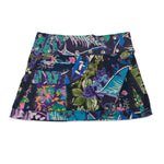 Kurzer Wenderock von Nijens mit kräftigen Grüntönen, tropischen Pflanzenmotiven, lila Blüten und Patchwork-Elementen – mit Tasche und schwarzer Spitze.