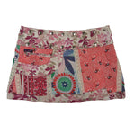 Rückseite des Wenderocks mit buntem Patchwork-Design, floralen Elementen und dekorativer Fronttasche.