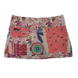 Rückseite des Wenderocks mit buntem Patchwork-Design, floralen Elementen und dekorativer Fronttasche.