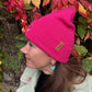 Frau trägt Fuchsia Beanie mit Pfote-&-Herz-Stickerei beim herbstlichen Spaziergang
