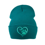 Beanie aus 100 % Acryl Türkisblau mit Herz-Pfoten-Stickerei. 