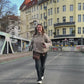 Frau trägt schokobraune Gassitasche aus Canvas mit echtem Leder als Crossbody in der Berliner Innenstadt und zeigt die Reißverschlussfächer unterwegs.