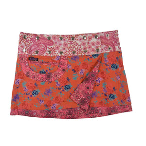 Kurzer Wenderock von Nijens mit orangem Grund und floralen Mustern in Türkis, Weiß und Lila – mit passender Tasche und Paisley Bunddesign.